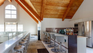 Coffee Bar inside clubhouse with refrigerator, bar stools, and coffee station.